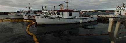 Booms line the port waters in Cap-aux-Meules in the Magdalen Islands in an effort to contain spilled diesel that might have leaked into the port.  